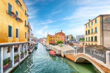 Gorgeous cityscape of Venice with narrow canals, boats and gondolas and bridges with traditional...