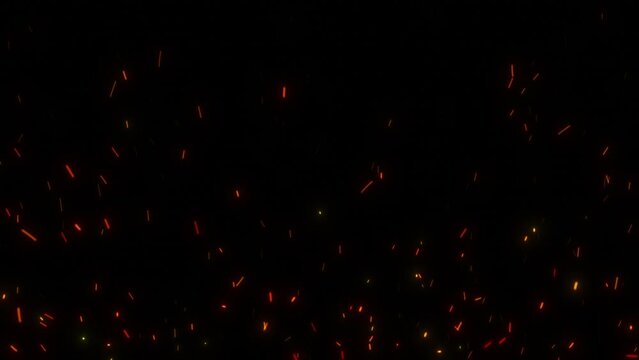 Flying sparks from the fire. Close-up of red-hot sparks of a fire flying upwards. Fire particles on a black background.