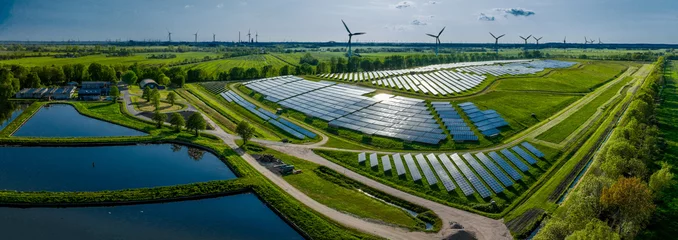 Tuinposter Environmentally friendly installation of photovoltaic power plant and wind turbine farm situated by landfill.Solar panels farm built on a waste dump and wind turbine farm. Renewable energy source. © snapshotfreddy