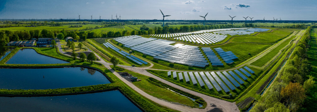 Environmentally friendly installation of photovoltaic power plant and wind turbine farm situated by landfill.Solar panels farm built on a waste dump and wind turbine farm. Renewable energy source.
