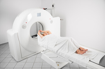 Medical computed tomography or MRI scanner. Woman patient lying on couchette, waiting for doctor....