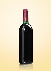 Red wine in glass bottle on pastel background.