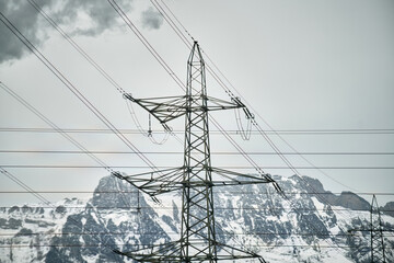 High voltage electric pole in the Alpine scenery. High voltage electric pole in mountains valley.