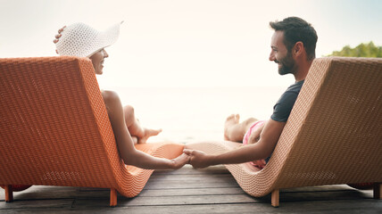 Relax, travel and deck with couple holding hands at hotel resort for bonding, luxury and summer...