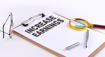 INCREASE EARNINGS text on clipboard on white background, business concept
