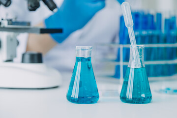 biochemical research scientist team working with microscope for coronavirus vaccine development in pharmaceutical research labolatory, selective focus