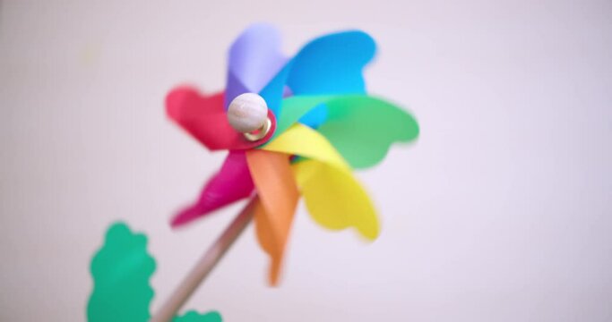 Colorful rainbow wind spiral. Plastic windmill rotates colored. Kids toy plastic turbine.