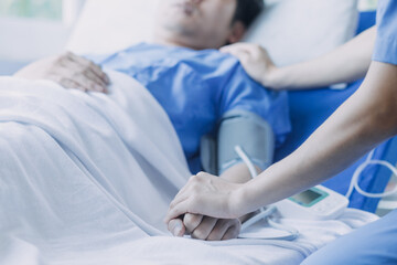 Obraz premium Asian caregiver doctor examine older patient use blood pressure gauge. Young woman therapist nurse at nursing home taking care of senior elderly woman sit on sofa. Medical insurance service concept