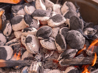 Starting up garden barbeque. Heating up charcoal stage. Burning coal. Summer time activity, Food preparation in a park or backyard.