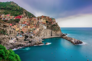 Fototapeta na wymiar Picturesque colorful village situated on the edge of a cliff in Manarola, Cinque Terre, Italy