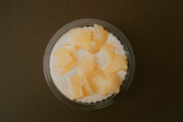 Top view of a mousse with a fruit topping isolated on brown background