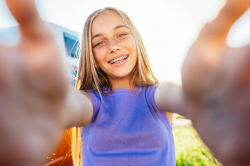 Beautiful young lady taking selfies with a bracket on her teeth.