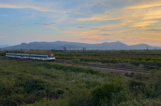 Train on railway. Spain regional commuter train in motion on railway. Spanish National Rail Network. Travel by train in European countries. Train against of mountains drive on railway