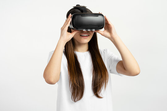 Excited Teenager girl using virtual reality glasses isolated on white background. Technology, innovation concept