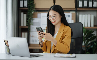 Businesswoman using mobile phone play social in office.