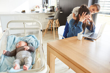 Mother with burnout in the home office with baby and child