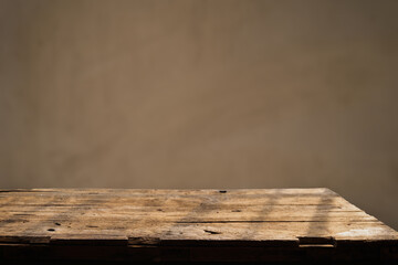 Empty wooden board on table top and blur inside over stucco wall blur background, mock up for display of goods.