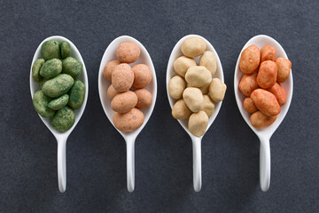 Variety of Japanese-style crunchy coated peanuts or cracker nuts with different flavoring (chives,...