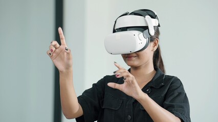 Young women wearing VR goggles posing finger touching on the air. Woman testing VR glasses or goggles working with virtual reality. Metaverse technology concept