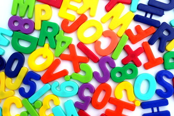 Many bright multi-colored letters lie on a white background.