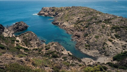 Fototapeta na wymiar Aerial view of Fredosa cove rocky beach surrounded by emerald water in Cap de Creus