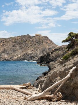 Aerial view of Gran de Culip rocky beach surrounded by emerald water in Cap de Creus