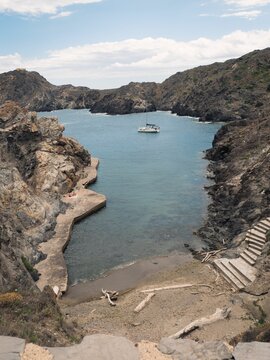 Aerial view of Gran de Culip rocky beach surrounded by emerald water in Cap de Creus