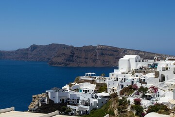 Fototapeta na wymiar Aerial view of Oia village marble buildings before the sea on a sunny day in Greece