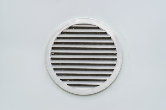 Round ventilation grate on grey wall