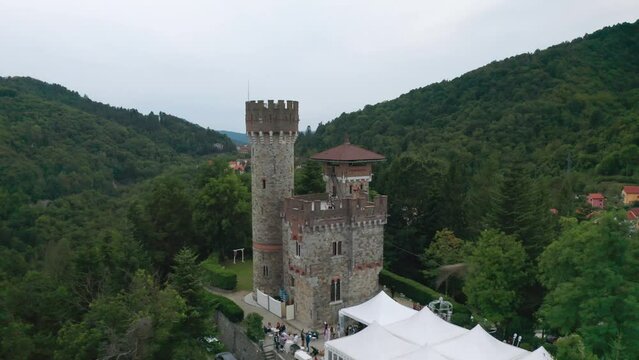Aerial pullback view of Giacomo Becchi Castle in lush woods, Italy