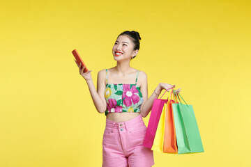 asian woman are holding shopping bags and smartphone with face happily