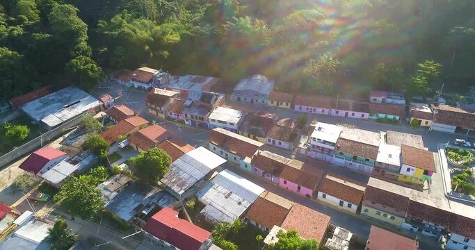 Sunset over small tropical village with red roofed houses surrounded by trees, Cepe Venezuela