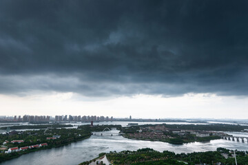 Dark clouds over a city by the sea