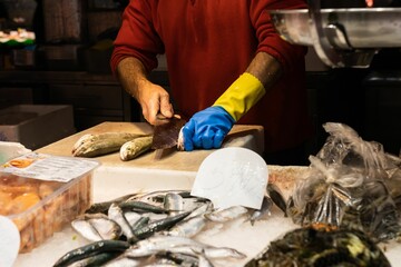 Fishmonger cleaning a fish.