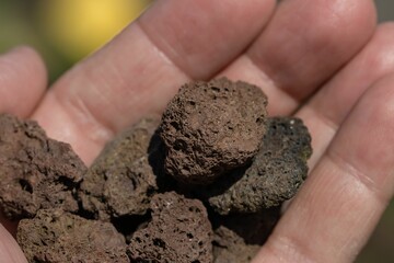 Close-up of hand with volcanic lava.
