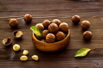 Shelled macadamia nuts in bowl with green leaves. Protein food