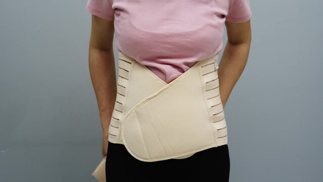 woman wearing lumbar support belts. pregnant and postnatal lumbar brace after surgery