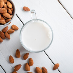 Fototapeta na wymiar Almond milk in glass with almonds on wooden background. 