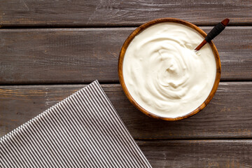 White dip sauce - sour cream or yogurt in wooden bowl