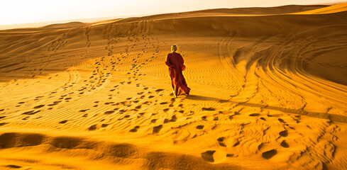 Woman in red walking on a dunes
