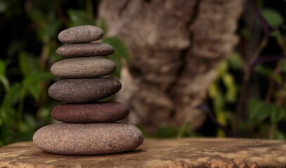 pebbles stacked atop a piece of tree trunks for relaxation in the garden