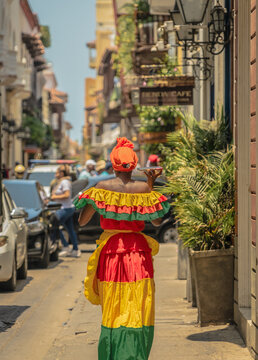 Colombian woman with typical dress of Cartagena de Indias walking through the streets. Travel photography. Trip to Colombia. Woman talking with her smartphone
