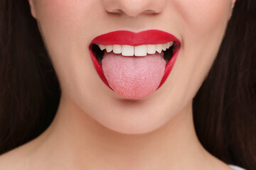 Woman with red lipstick showing her tongue, closeup