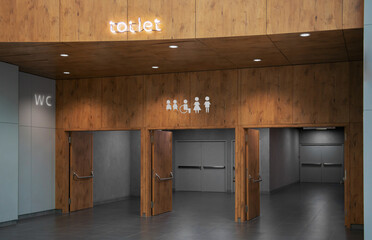 Public toilet signs on wooden wall over entrance