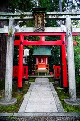 Fotobehang Vertical shot of torii traditional japanese gate at the entrance of a Shinto shrine © Ervin Zhao/Wirestock Creators