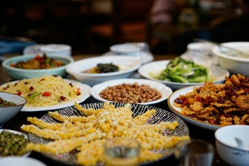 Closeup of golden crunchy Chinese corn cake with other dishes on the table.