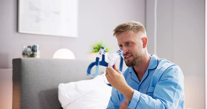 Shocked Young Man Holding CPAP Machine