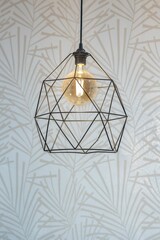 Fototapeta na wymiar Black pendant lamp shade hanging on ceiling, vertical shot