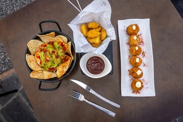 Top view of fried mozzarella balls served with ketchup and nachos in a restaurant