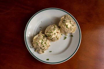 Top view of German Bread Dumplings sprinkled with parsley and chive and served on a ceramic plate